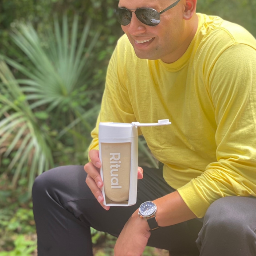 Man holding a Ritual protein shaker filled with Essential Protein.